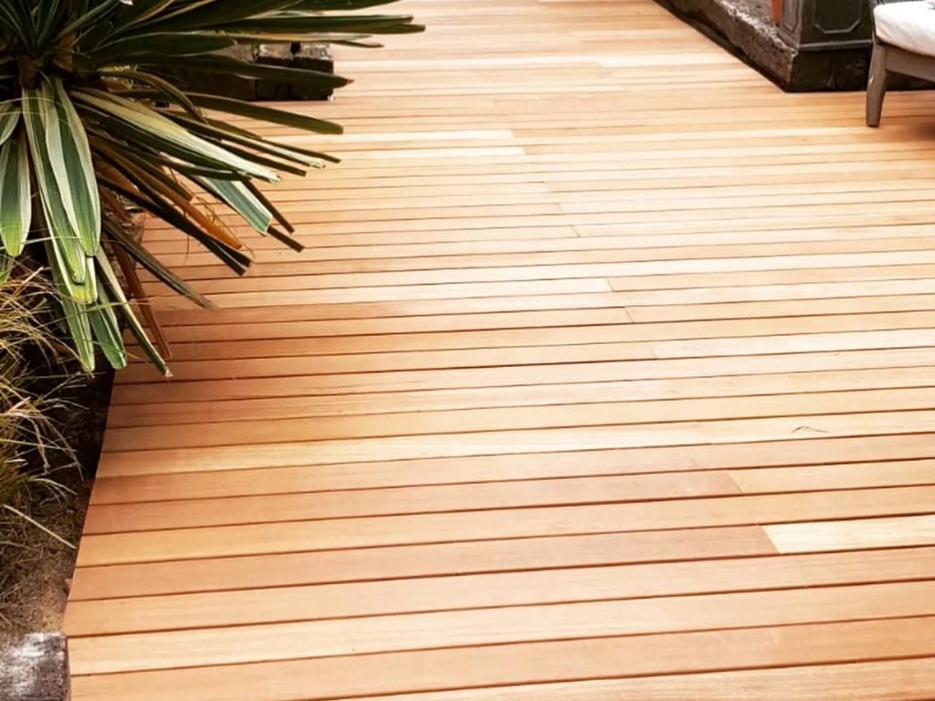 Long timber deck creating an outdoor living area alongside established planting.